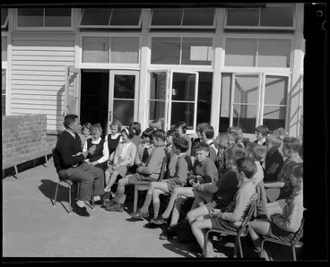 Image: Man playing ukelele for a group of schoolchildren