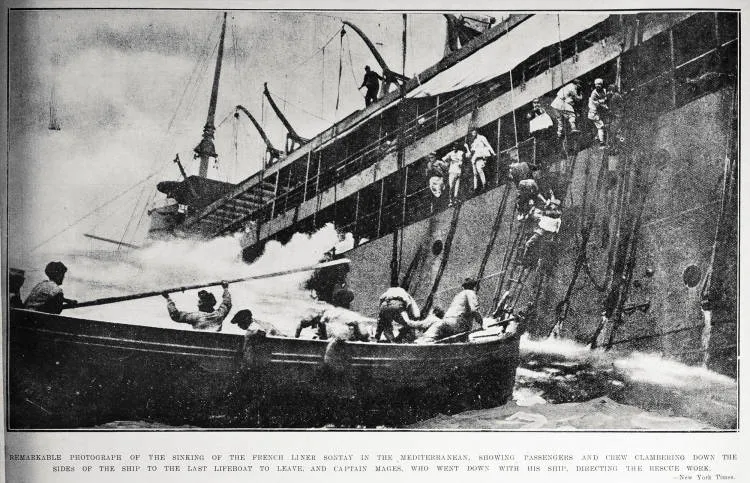 Remarkable photograph of the sinking of the French liner Sontay in the Mediterranean, showing passengers and crew clambering down the sides of the ship to the last lifeboat to leave and Captain Mages, who went down with his ship, directing the rescue work