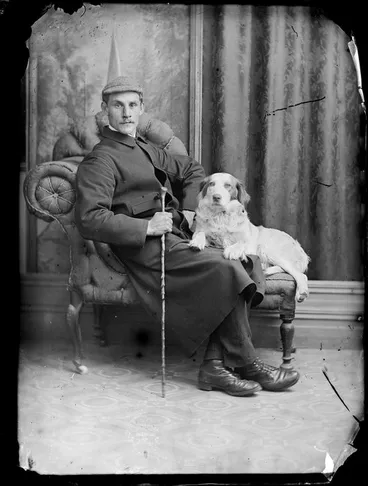 Image: Unidentified man, seated, with his dog