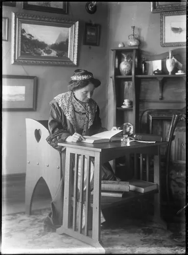 Image: Woman seated at a table reading