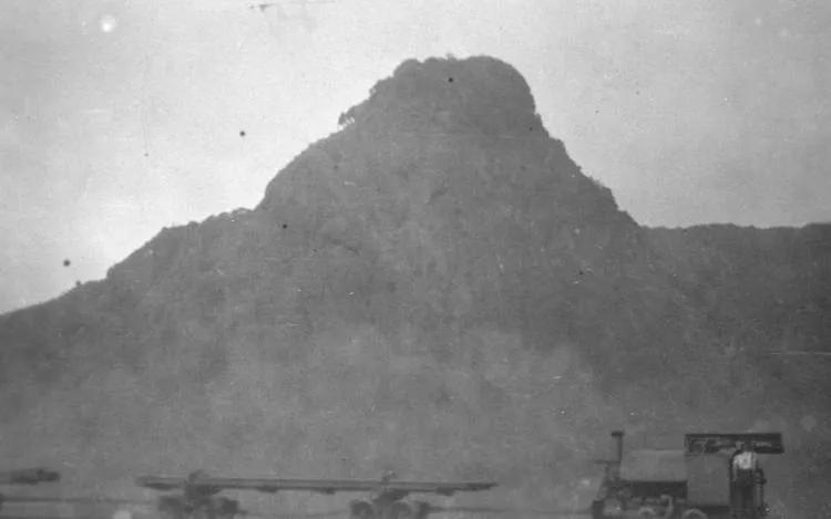 Engine and empty trucks on the beach at Karekare.