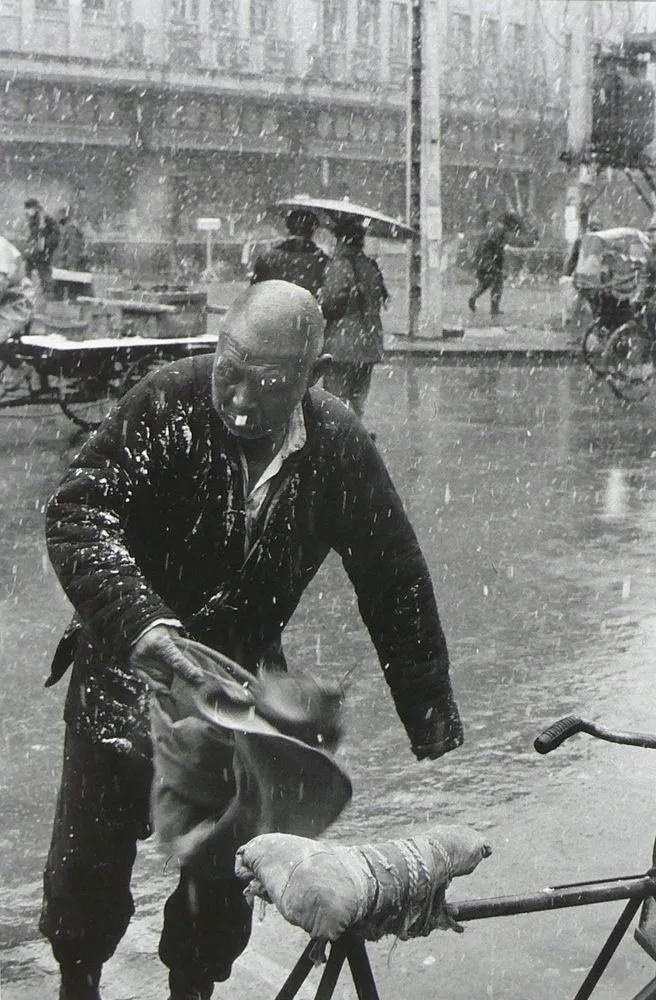 Old man in the snow rushing to his bicycle