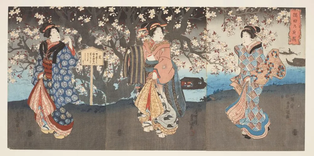 Three women viewing cherry blossom on a riverbank.