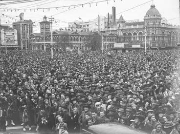 Image: Celebrations. Crowd at WWII, Victory over Europe ( VE ) Day Celebration. Held 9 May 1945, Pipe Bandsman front Left. Cathedral Square, Christchurch, Canterbury, New Zealand.