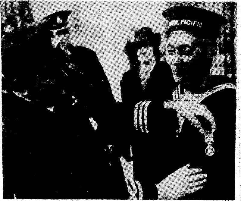 Commander L. Goddard, chief officer of H.M. transport Empress of ', Japan, pinning the B.E.M. on his Chinese quartermaster, Ho Kan, for heroic work during convoy duties. (Evening Post, 25 June 1942)