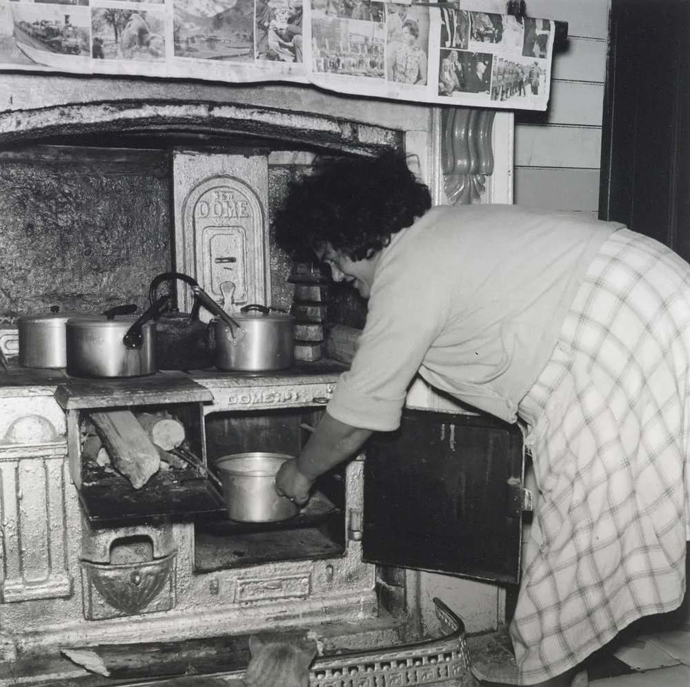 Mrs Wereta stokes the fire. She has made dough... From the series: Washday at the pa