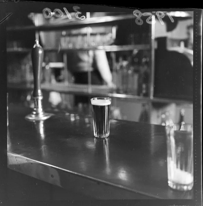 Glass of beer showing short measure of 8d beer from a Wellington hotel