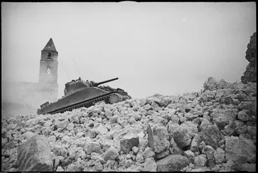Image: NZ Sherman tank climbs over ruined buildings on the Cassino Front, Italy, World War II - Photograph taken by George Kaye