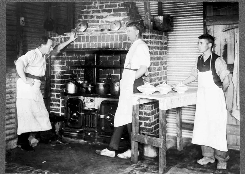 Waitaki Farmers' Freezing Company, Pukeuri, early 1920s. Three gentlemen with aprons on in front of range cooking
