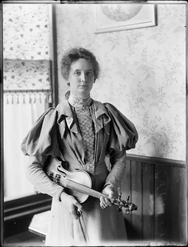 Image: Nellie Devereux holding [viola? violin?], location unknown