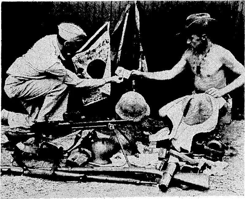 An Australian trooper (right) arid an American soldier examining Japanese arms, flags, some' money; and odds and ends of equipment captured in New Guinea. (Evening Post, 30 October 1942)