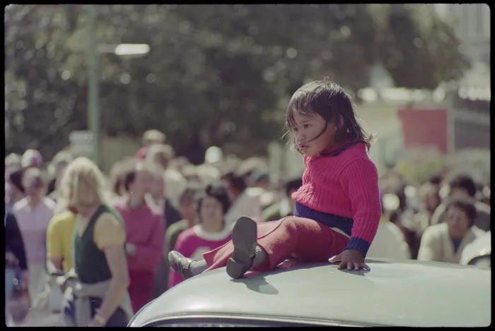 Child sitting on roof of car