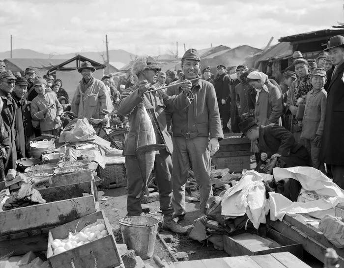 Fishseller at Hiroshima market weighing fish with primitive but effective steel-yard