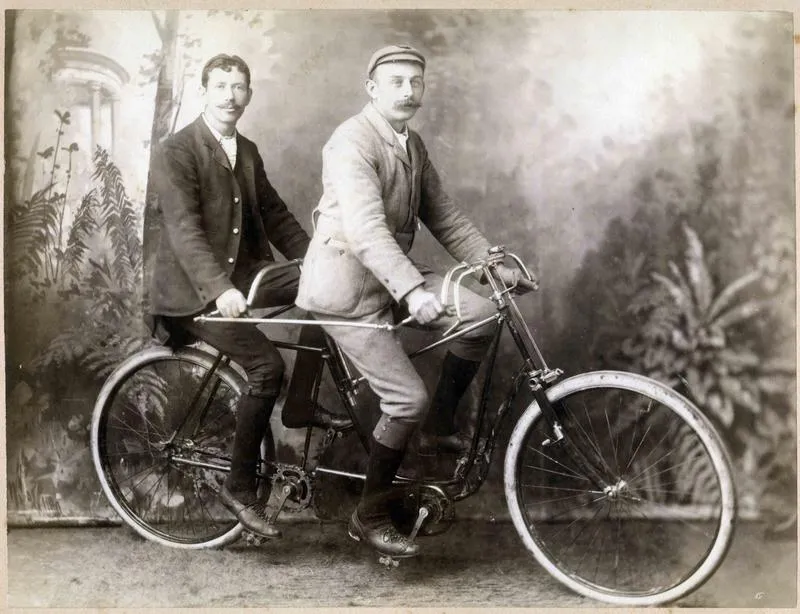 Two men on a Raleigh tandem bicycle.
