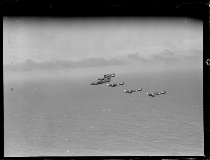 Group of Curtiss P-40 Kittyhawk aircraft flying in formation over ocean