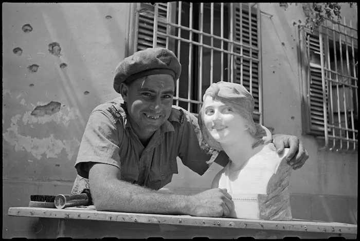 T K Norman poses with female bust found in wrecked house in San Casciano, Italy, during World War II - Photograph taken by George Kaye