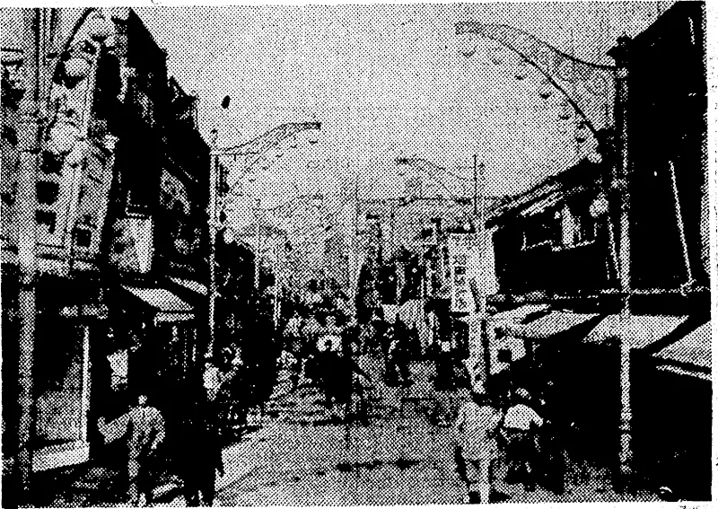 Moto-Machi, the main street of the shopping area in the port of Kobe, sixth largest city of Japan, which is among the centres heavily attacked by Super-Fortresses. (Evening Post, 06 June 1945)