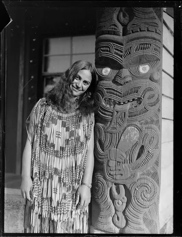 Image: Portrait of Matarita Smallman (nee Pitiroi) of Turangi standing next to an ornately carved amo