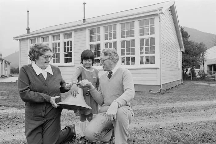 Gail Howard, Eileen Taylor, and principal Norman Wright with the original Wainuiomata school bell - Photograph taken by Ian Mackley