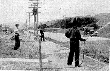 Image: Residents of'Waiwhetu Road, Lower Hutt, watering the road in ifront t.r ■ r J■ , j y Ai j j. 7- '•■ •• '!■'■ • Ajt oftheir homes'tokeep down the dust which arises from passing traffic. (Evening Post, 24 February 1939)
