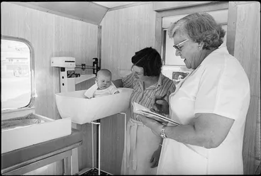 Image: Nurse weighing a baby in a mobile Plunket unit