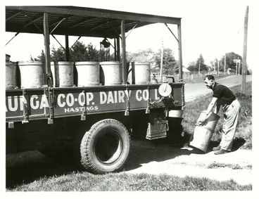 Image: Truck driver checks weight of milk cans
