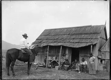 Image: Maori group alongside a dwelling at Ohura