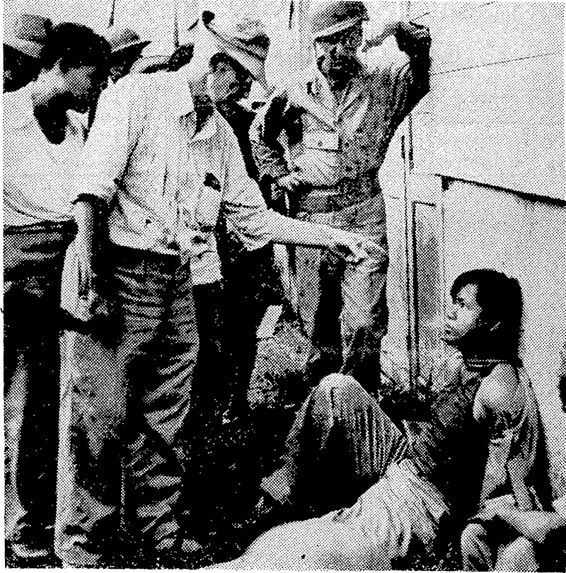 An American leader of the Filipino guerrillas during the Japanese occupation of Manila, points an accusing finger at a Chinese Filipino charged tviih being a Japanese spy. (Evening Post, 10 March 1945)