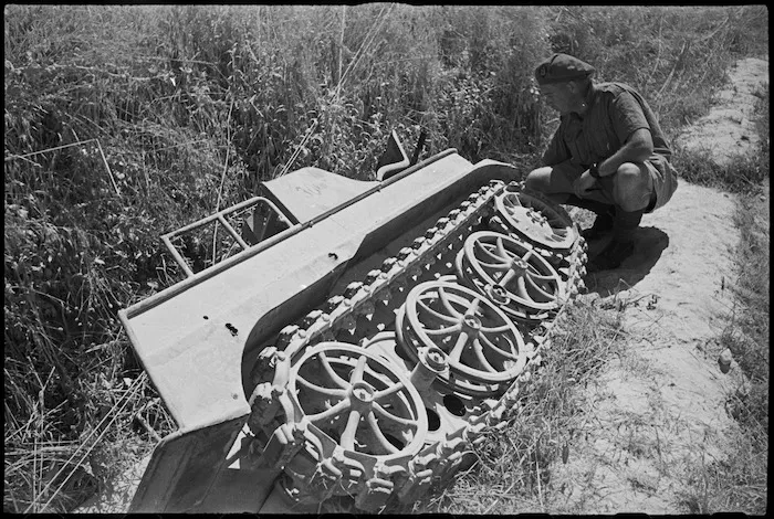 New Zealander G Lang inspects a small German armoured vehicle abandoned outside Sora, Italy, World War II - Photograph taken by George Kaye