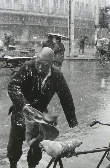 Image: Old man in the snow rushing to his bicycle