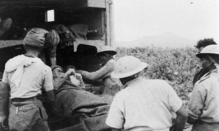 D'Arcy, C N (Dr), fl 1943 (Photographer) : Loading an ambulance for wounded Maori Battalion soldiers, Takrouna, Tunisia