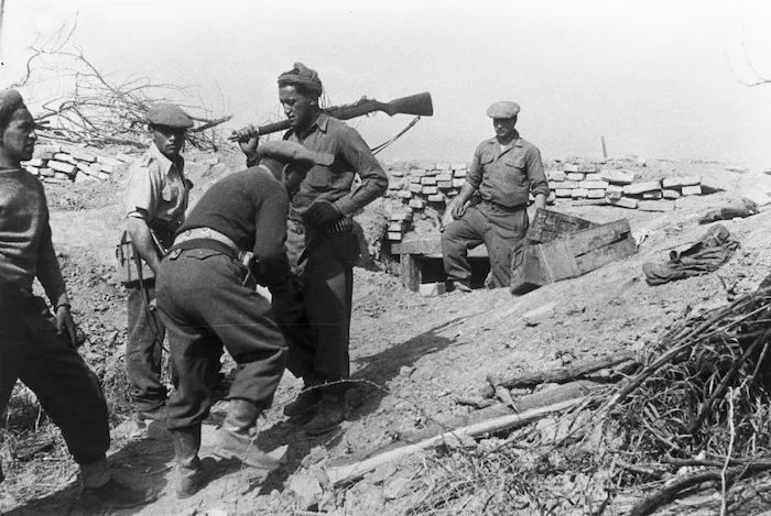 Gasson, J A, fl 1945 (Photographer) : Soldiers of the Maori Battalion on the Santerno River stopbank, Italy