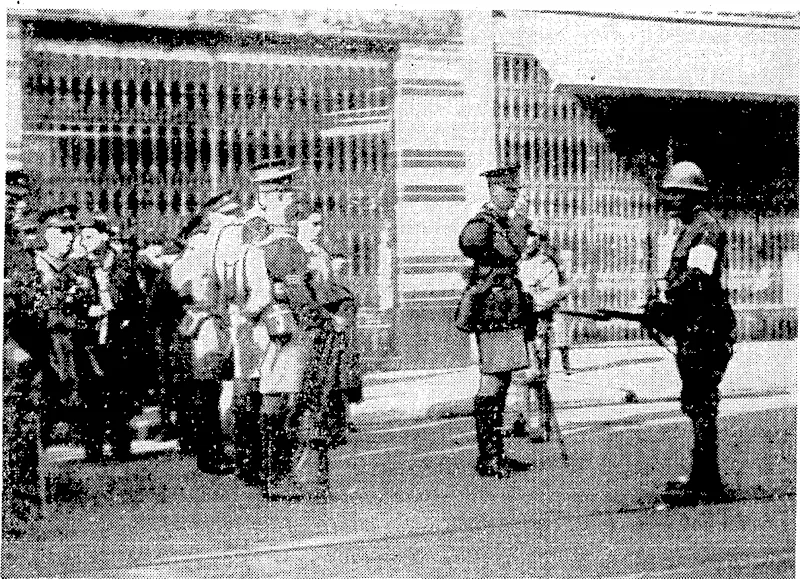 Sport and General" Photo. Japanese soldiers attempt to hold up a. platoon of the Royal Welch Regiment following a bombing incident on the Nanking Road on December 3, ivhen a bomb was throivn at the Japanese victory parade. Later British troops passed through the cordon ■ which the Japanese threiv round the area where the ",'..,' ■ bombing occurred. (Evening Post, 11 January 1938)