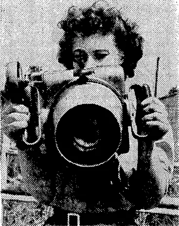 Image: A member of the W.A.A.F., specially trained as an instrument repairer, checking the sights of an air camera. (Evening Post, 21 August 1941)