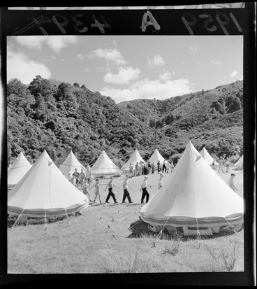 Image: Boys' Brigade camp, [Rimutaka Forest Park?] Wainuiomata, Lower Hutt, showing boys marching around perimetre of campsite