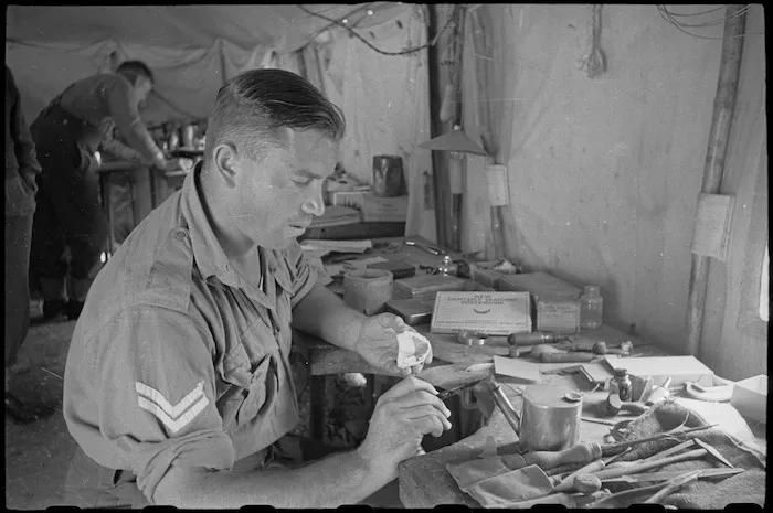J Franklin waxes up a partial denture at Headquarters of the 1 New Zealand Mobile Dental Unit, Volturno Valley, Italy - Photograph taken by George Bull