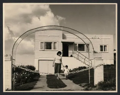 [Mother and child in front of house]