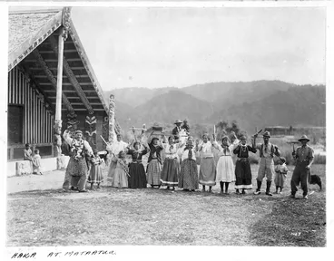 Image: Maori men, women, and children, performing a haka at Mataatua