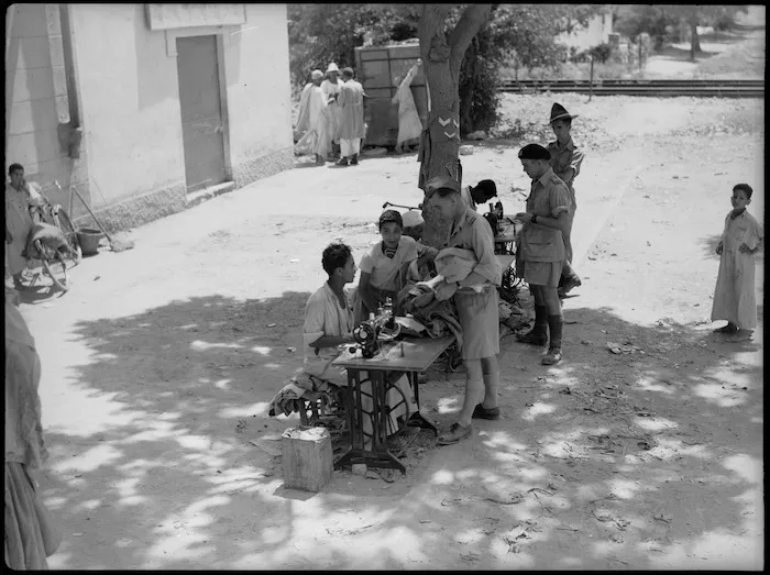 Native tailors in Maadi village make minor alterations to the uniforms of New Zealanders from the nearby camp, World War II - Photograph taken by G Kaye