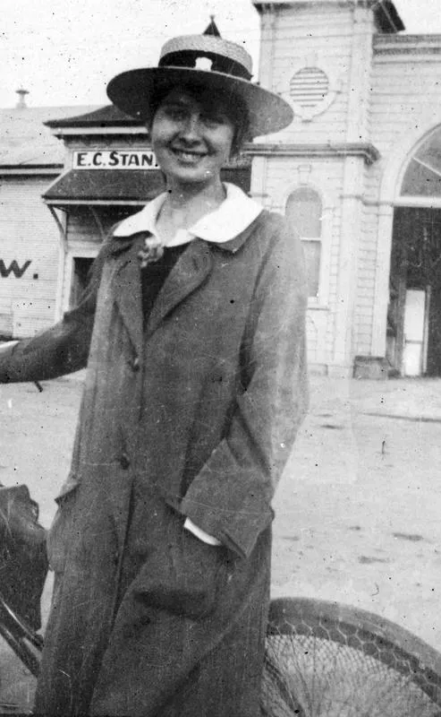 Margaret Douglas standing with her bicycle outside the Winter Show Buildings