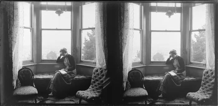 Lydia Williams reading at the window of their house, Dunedin