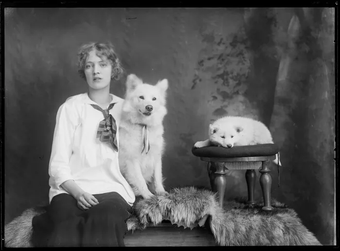 Studio portrait of an unidentified young woman with two husky dogs, possibly Christchurch district