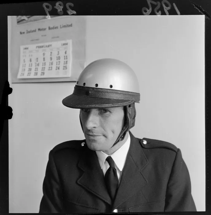 An unidentified official [policeman?] models a safety helmet at the time they became compulsory for motorcyclists
