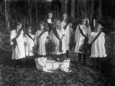 Image: Young girls standing around a baby's coffin