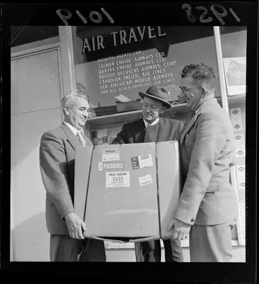 Image: Three unidentified men holding a carton of Polio Vaccine, standing outside the Tasman Empire Airways Ltd office