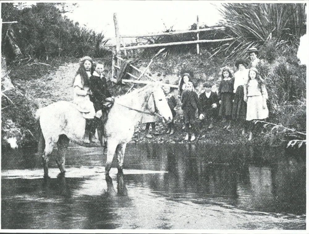 On their way to school: children fording the river, Waikawa Valley