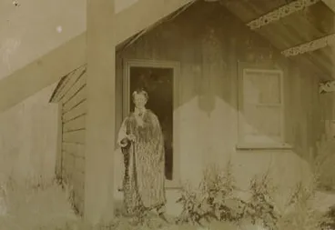 Image: [Goldie Wearing a Kahu Standing in Front of Whare ...]