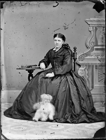 Image: Mrs Quick, seated with a dog looking rather like a teddy bear