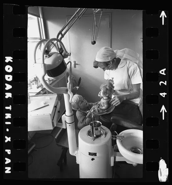 Karen Wisse looking at a doll with dental nurse