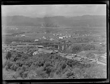 Image: View over the settlement of Kakahi, with sawmill, stacked timber, rail yards and bridge and residential houses with forest covered hills beyond, Manawatu-Whanganui Region